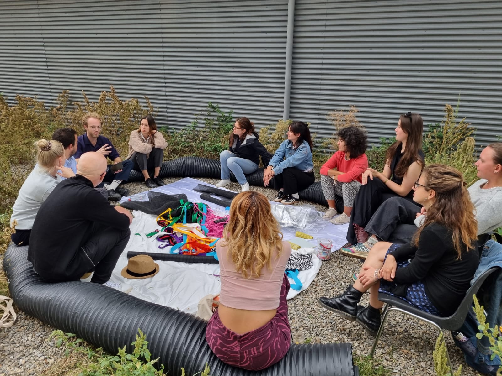 Group of people sitting in a circle outdoors during a participatory workshop